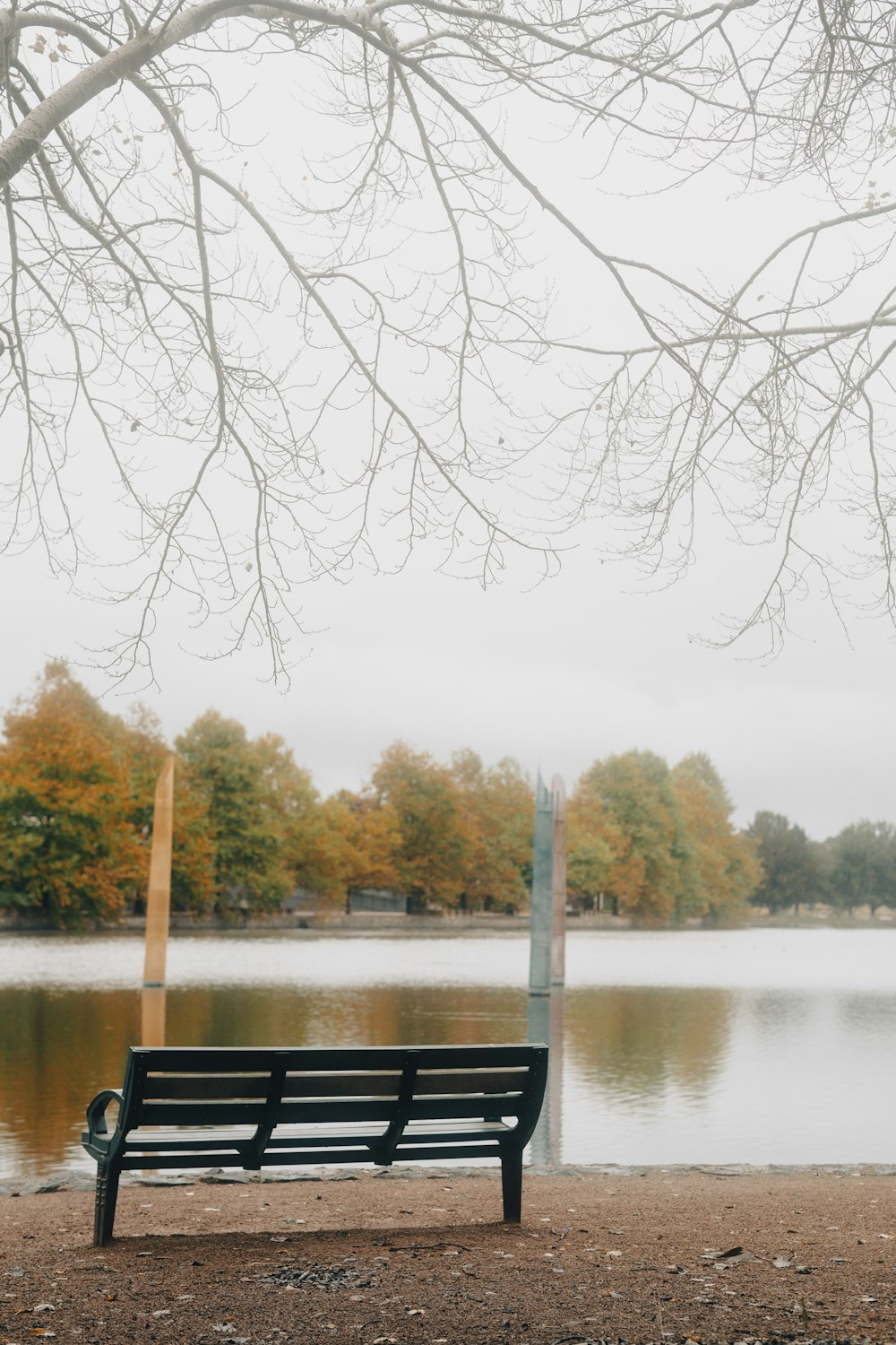 una panchina del parco seduta di fronte a uno specchio d'acqua