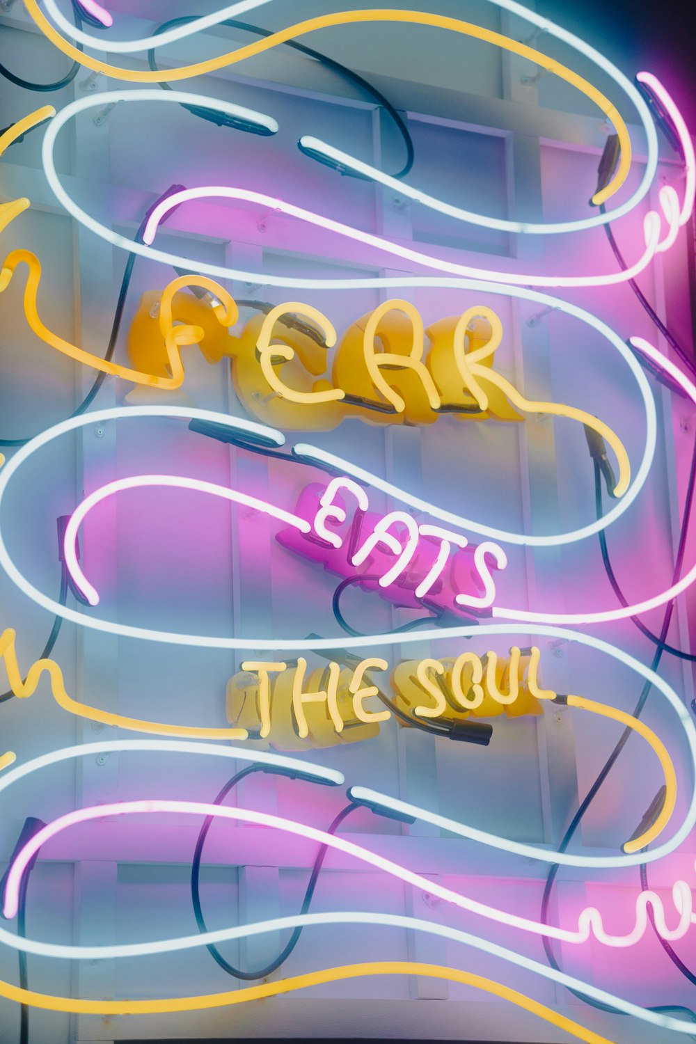 a neon sign that says fear eats in the soul