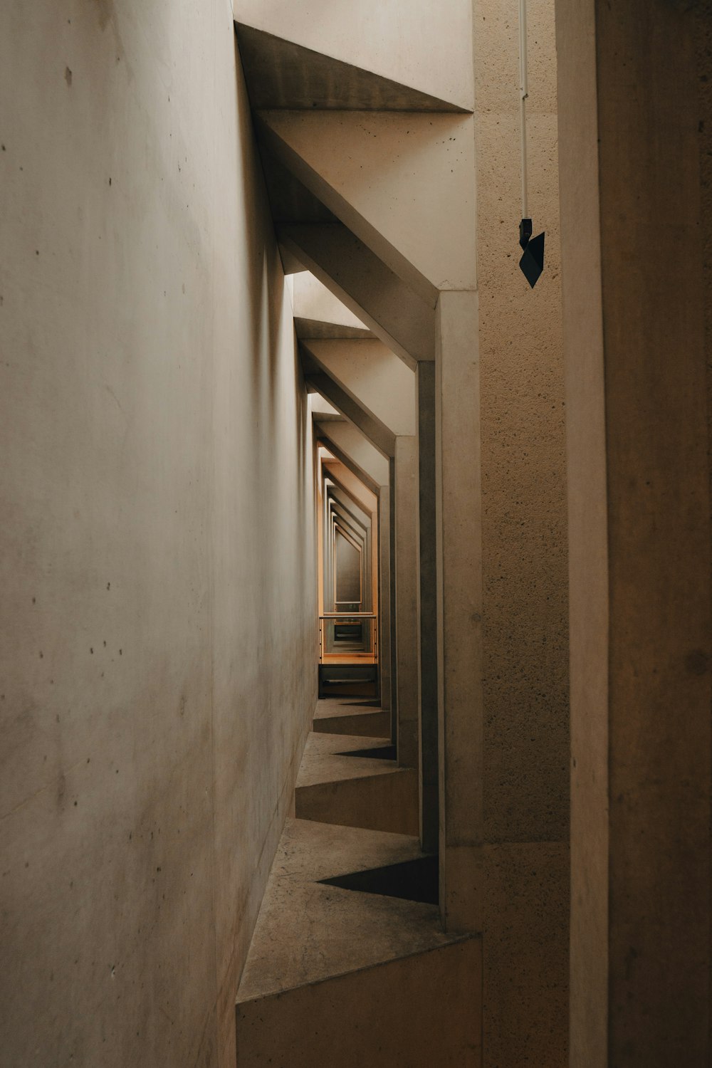 a long narrow hallway with a light at the end