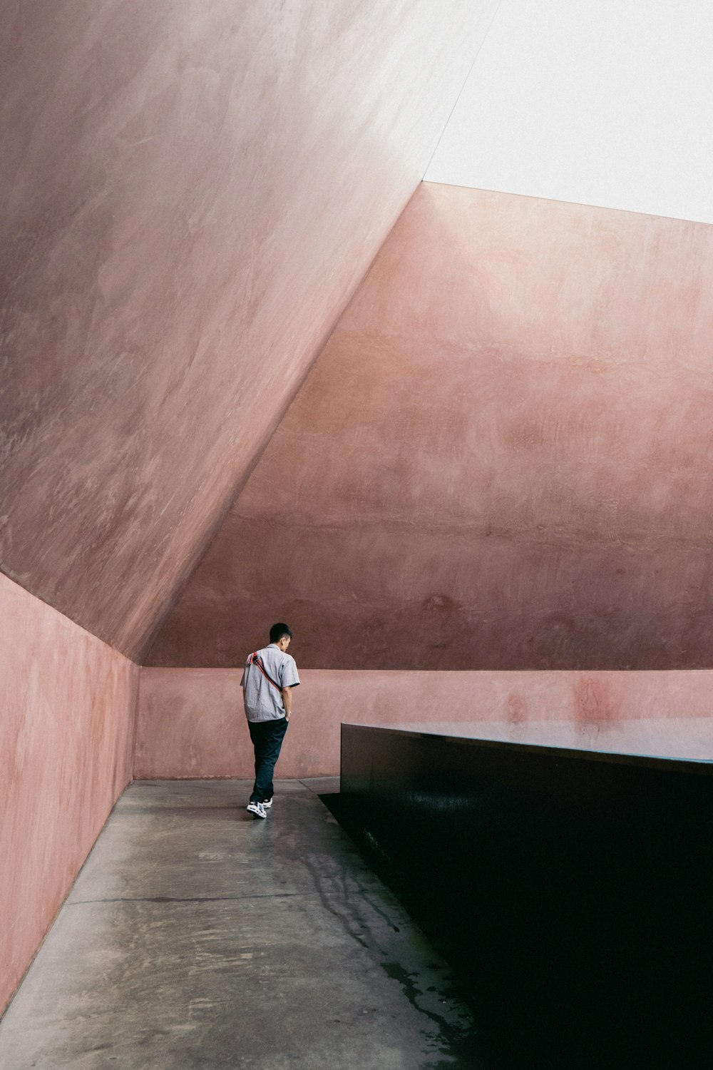 a person standing in a room with a pink wall