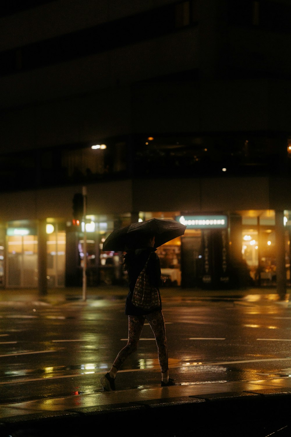 a woman walking down a street holding an umbrella