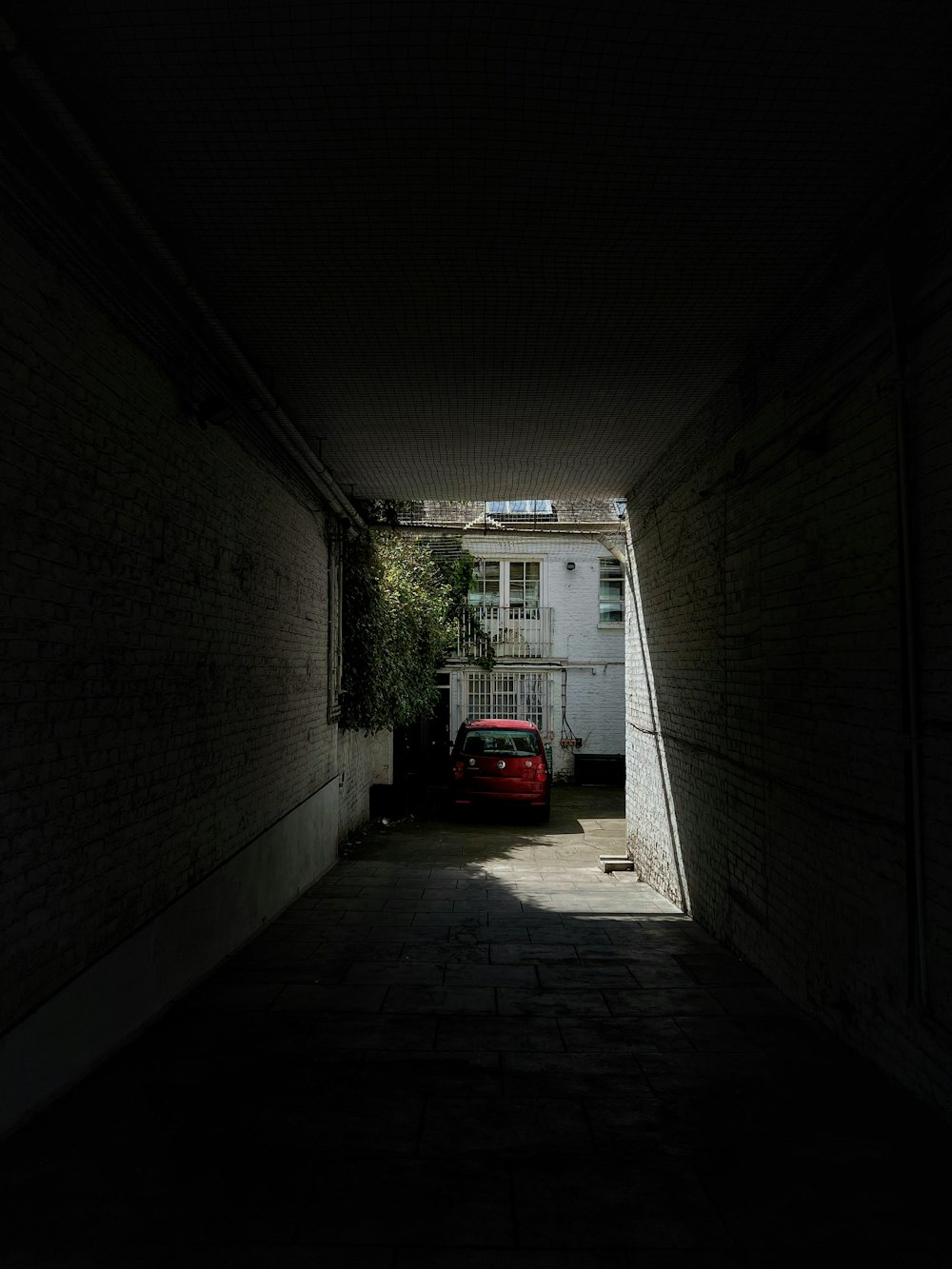 a red car is parked in a dark alley