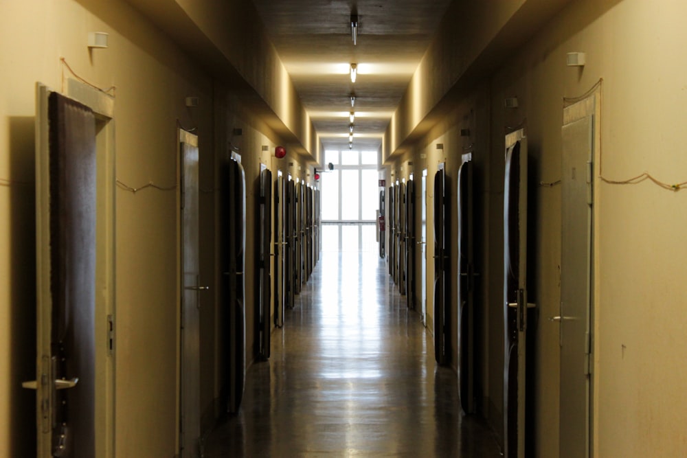 a long hallway with several doors leading to another room