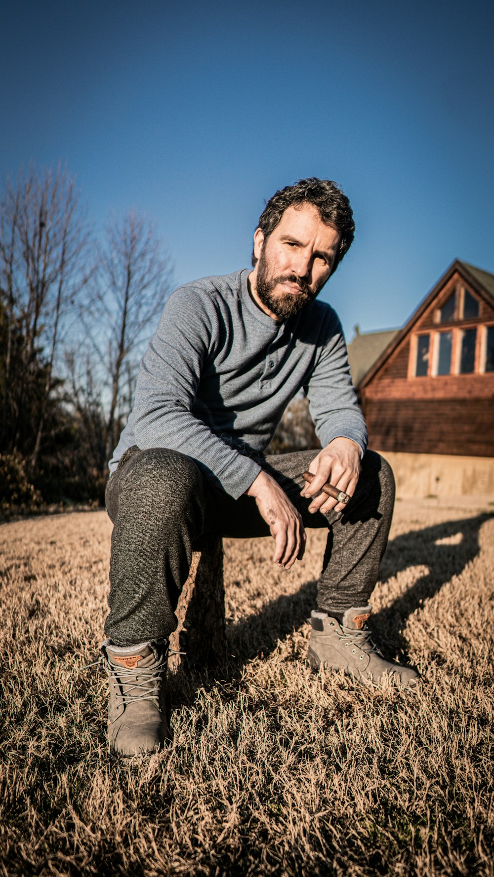 a man sitting in the grass with his foot on the ground