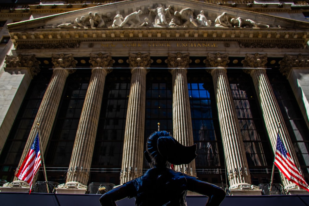 a statue of a woman standing in front of a building