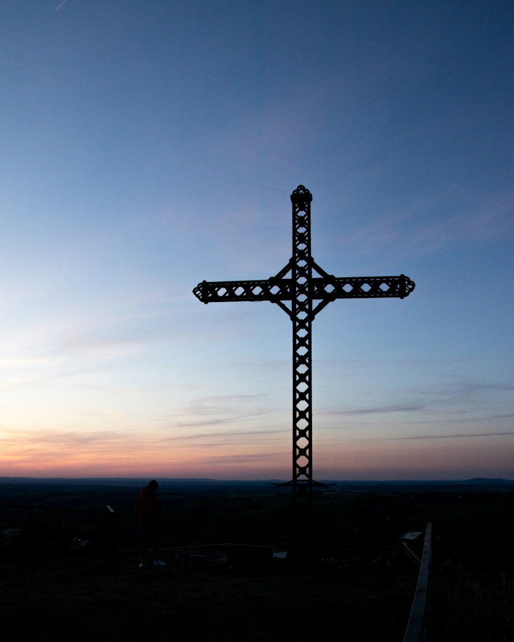 a large metal cross on top of a hill