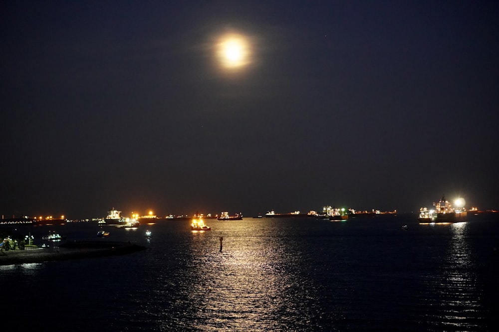 a full moon is seen over the water at night