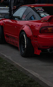 a red sports car parked on the side of the road