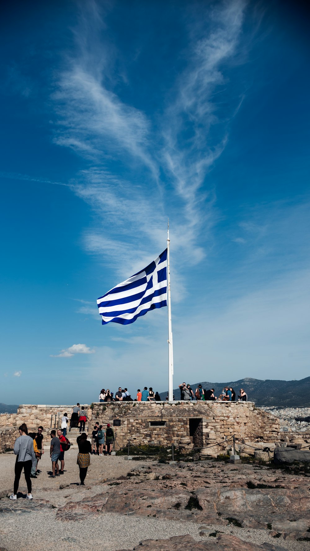 a group of people standing around a flag on top of a hill