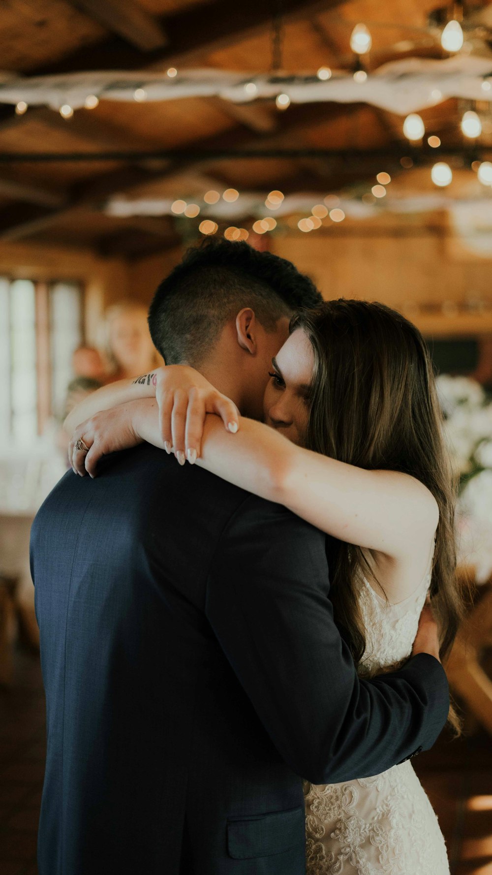 a bride hugging her groom in a barn