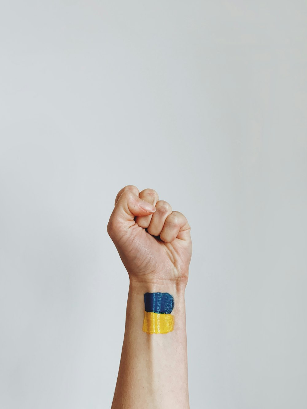 a hand with a yellow and blue wristband