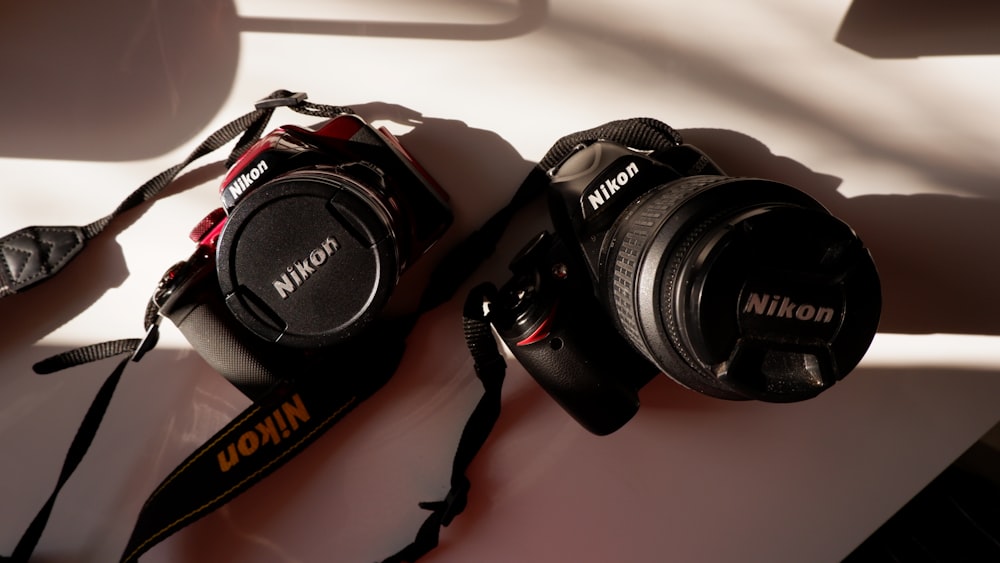 two cameras sitting next to each other on a table