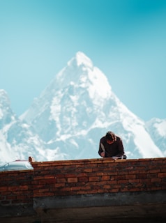 Close-up of a team member writing goals on a glass wall with mountains blurred in background