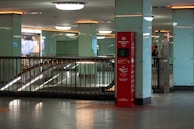 Rows of hand sanitizer dispensers installed in a busy educational facility hallway.