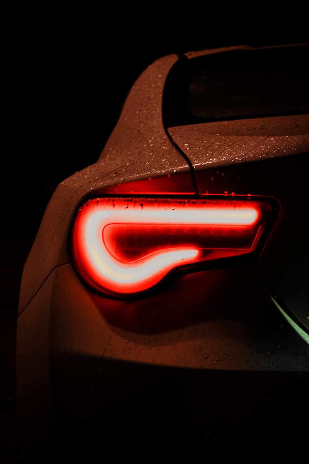 the tail light of a sports car in the dark