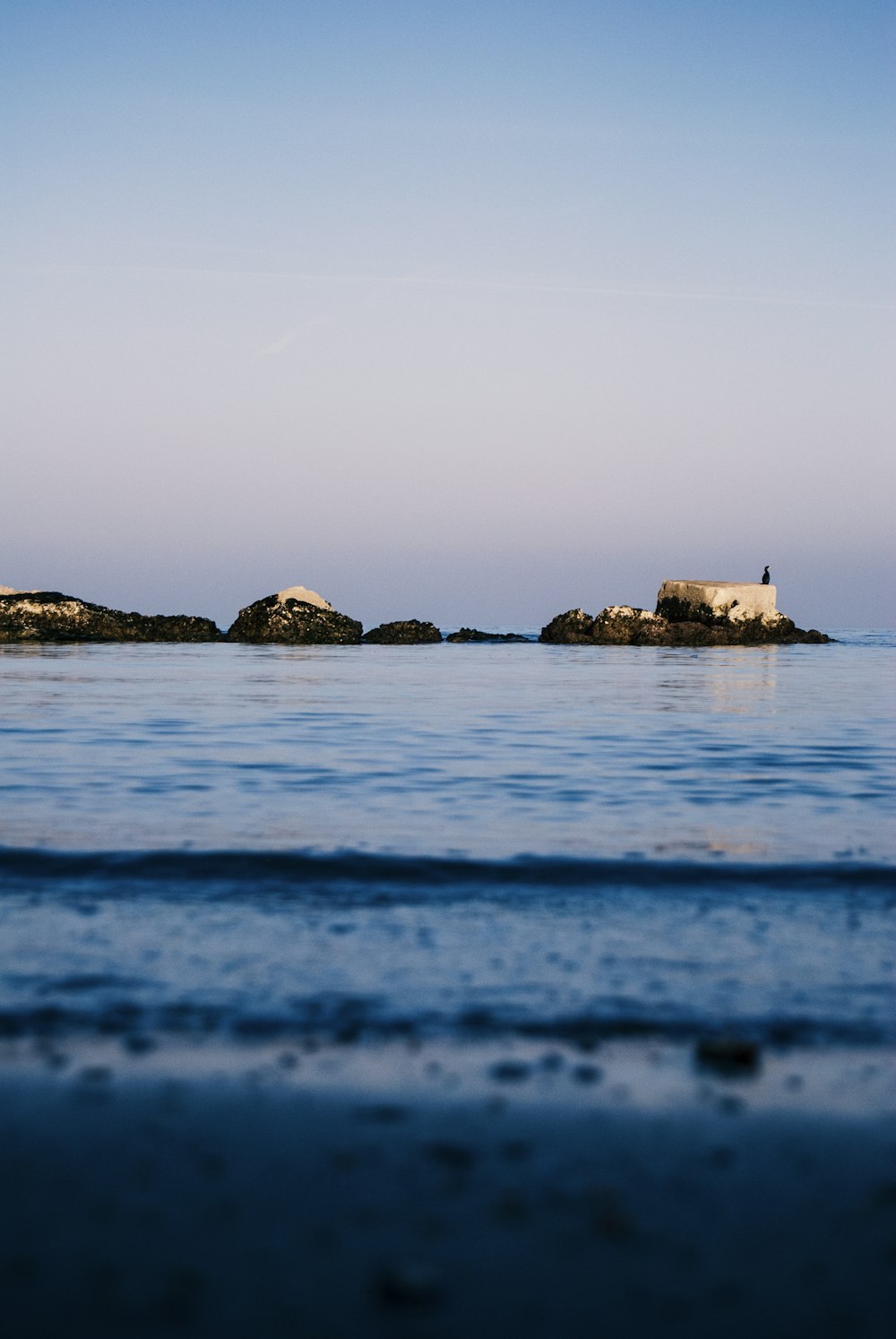 a lighthouse on a small island in the middle of the ocean