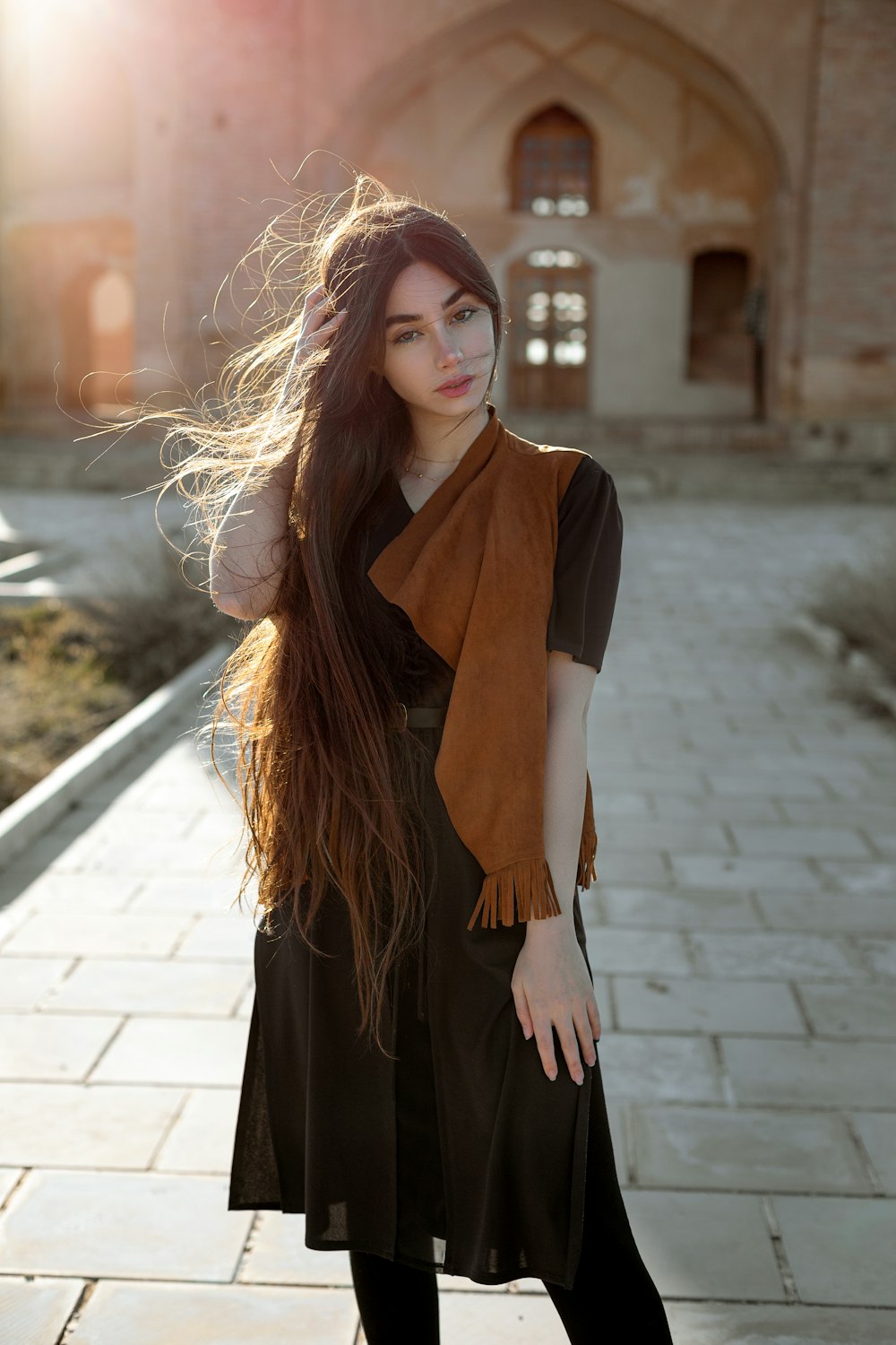 a woman with long hair standing in front of a building