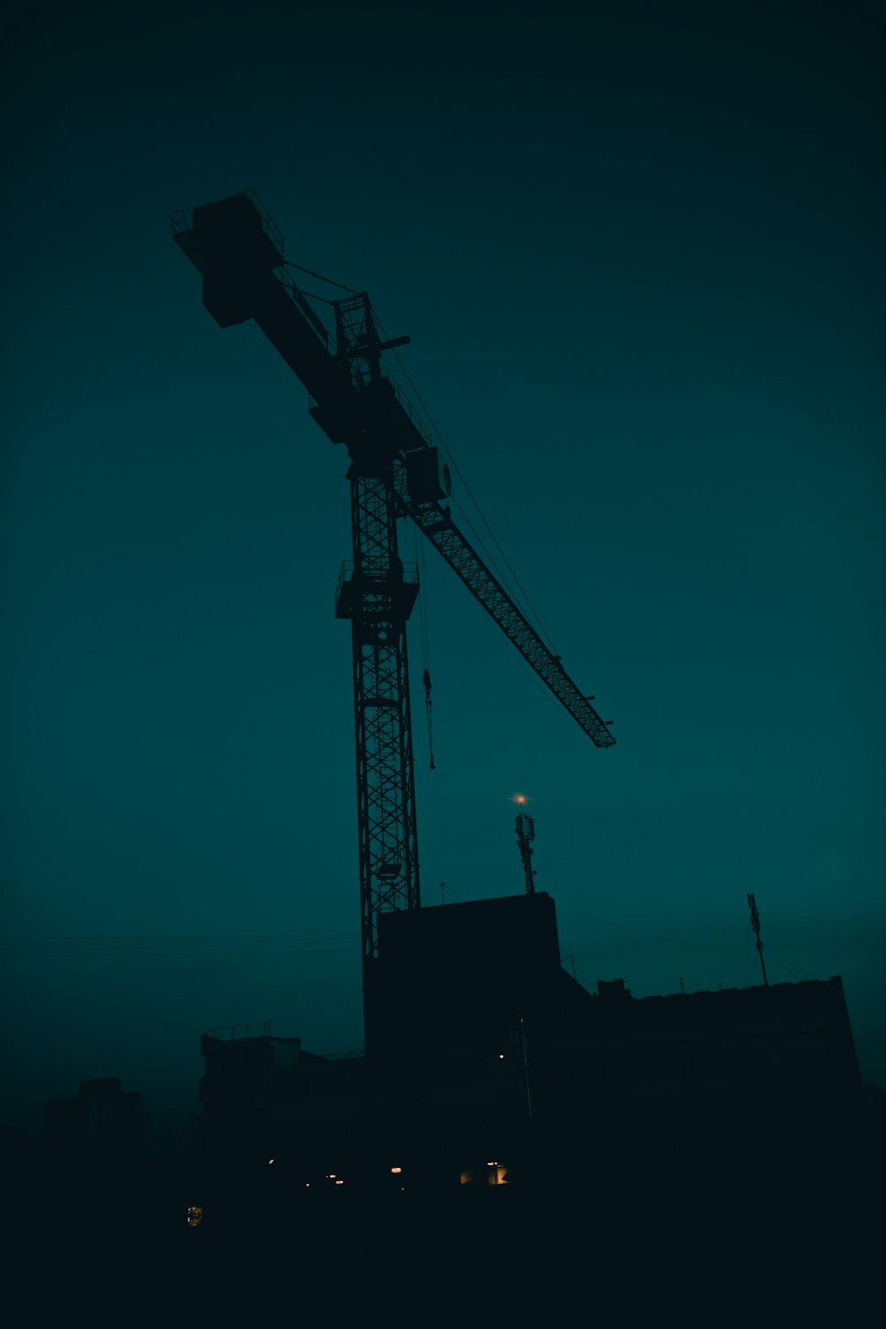 a large crane is silhouetted against a blue sky