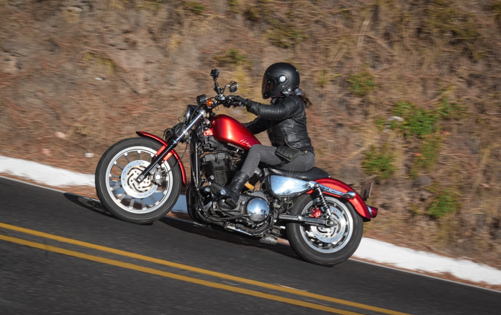 a man riding a red motorcycle down a curvy road