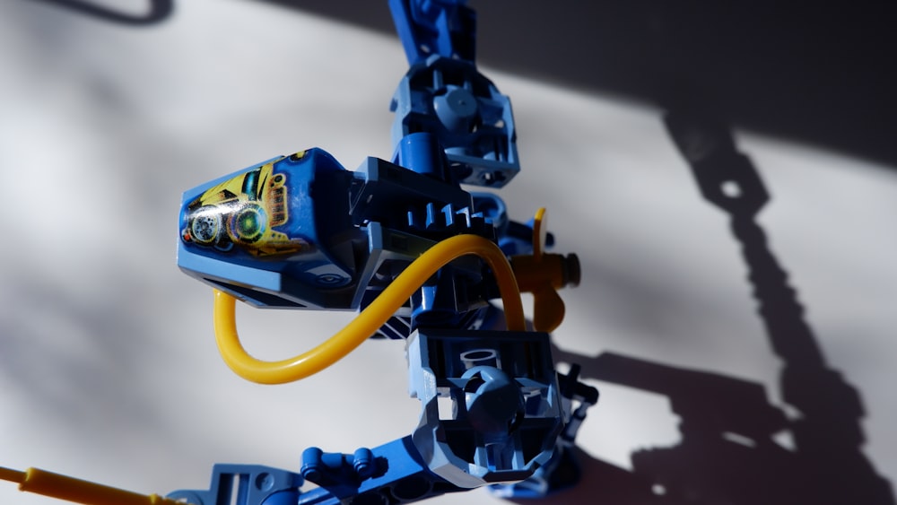 a close up of a lego robot with a yellow hose