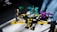 Four colorful toy robot figures arranged on a white surface, each in different postures with bright lighting casting shadows on some parts. The toys are primarily composed of pieces in bright yellow, turquoise, purple, and beige.