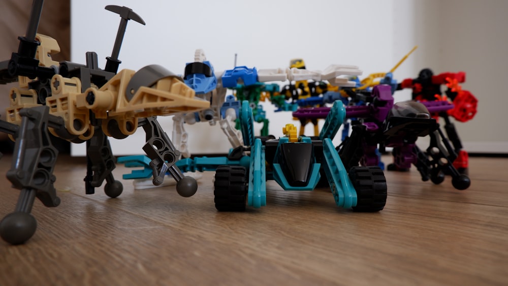 Un gruppo di veicoli giocattolo seduti sopra un pavimento di legno