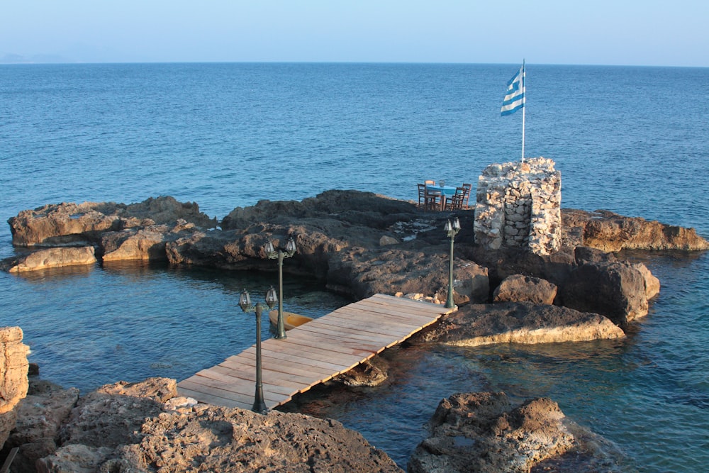 a dock with a flag on top of it next to a body of water