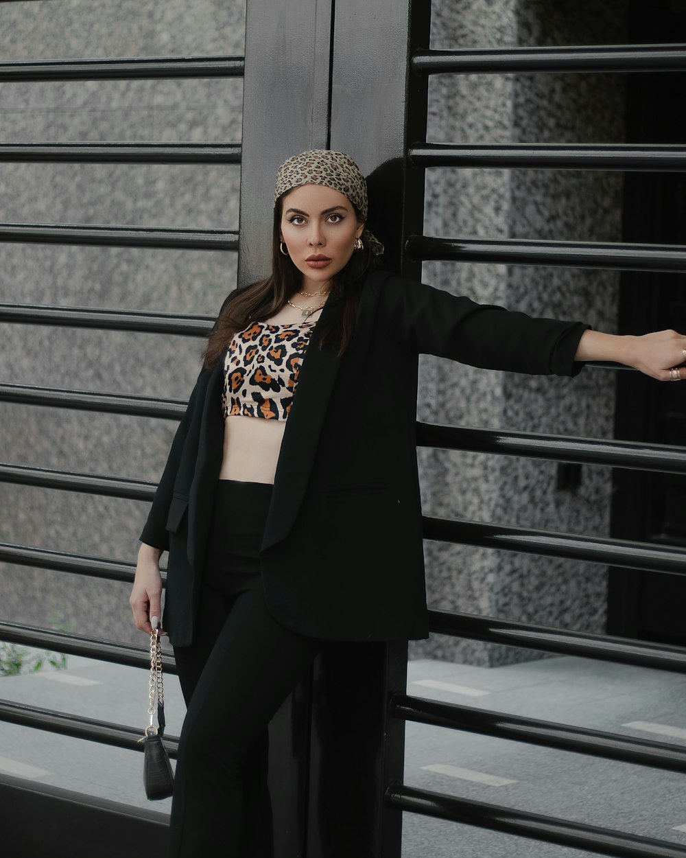 a woman wearing a leopard print top and black pants