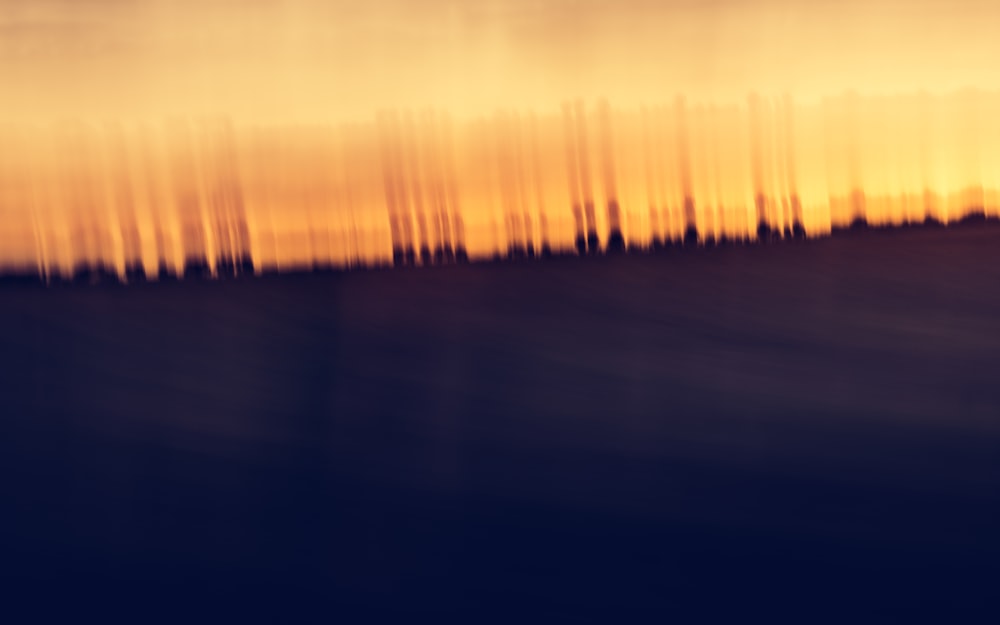 a blurry photo of a field with trees in the background