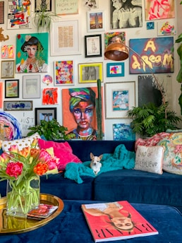 a living room filled with a blue couch and lots of pictures on the wall