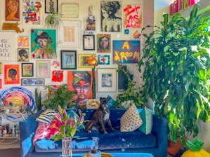 a living room with a blue couch and lots of pictures on the wall