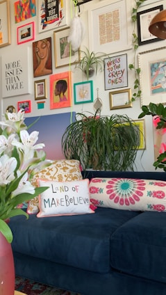 a living room with a blue couch and lots of pictures on the wall