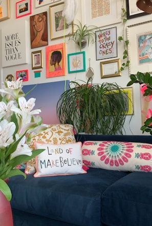 a living room with a blue couch and lots of pictures on the wall