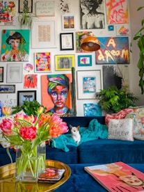 a living room filled with a blue couch and lots of pictures on the wall