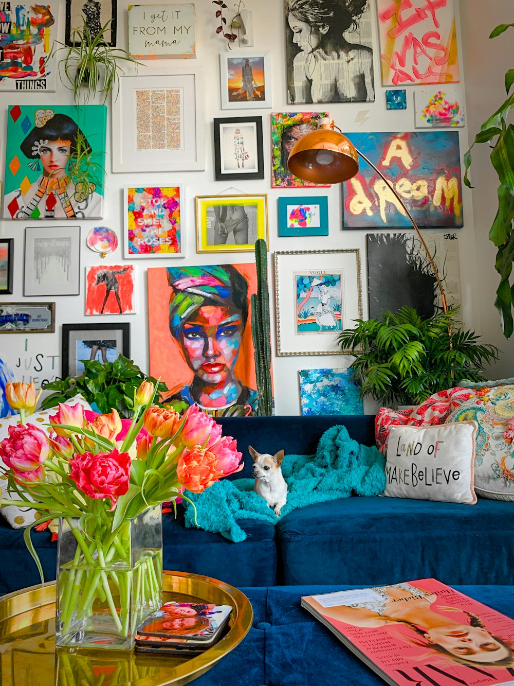 Un soggiorno pieno di un divano blu e un sacco di immagini sul muro