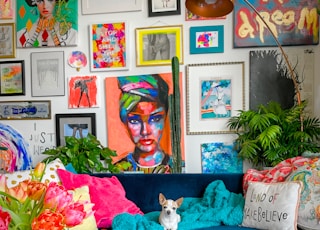 a living room filled with a blue couch and lots of pictures on the wall