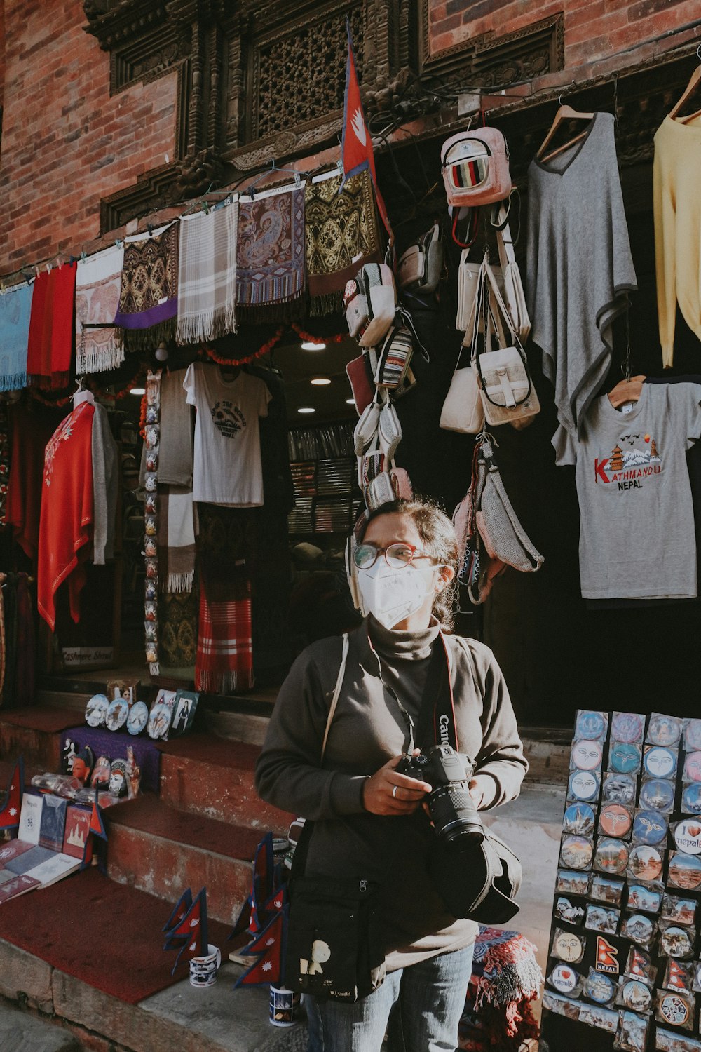 a man wearing a face mask standing in front of a store