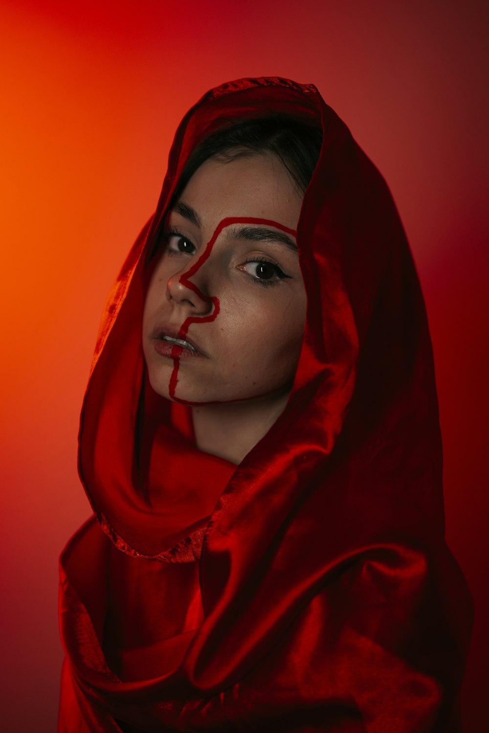 顔に血がついた赤いパーカーを着た女性