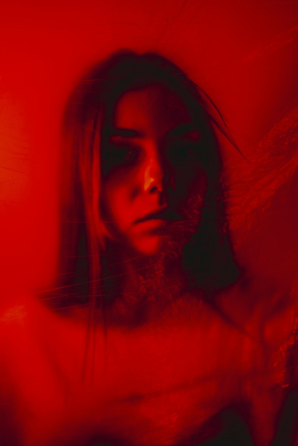 a woman with long hair standing in front of a red wall