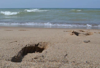 a small hole in the sand on a beach