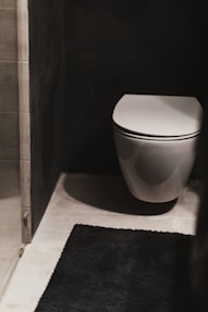 a white toilet sitting in a bathroom next to a shower