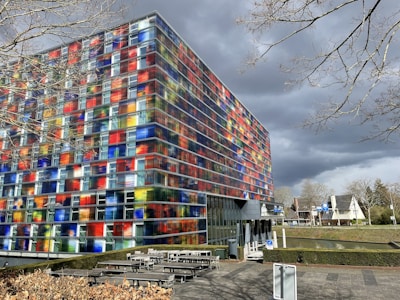 a multicolored building with benches in front of it