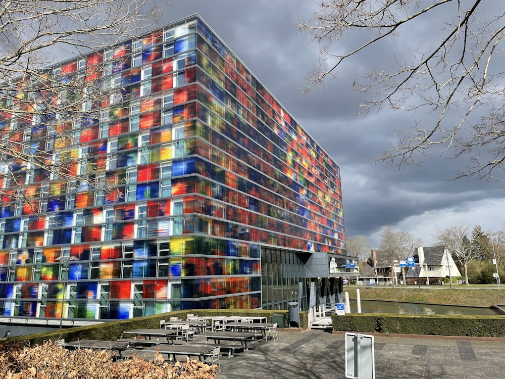 a multicolored building with benches in front of it