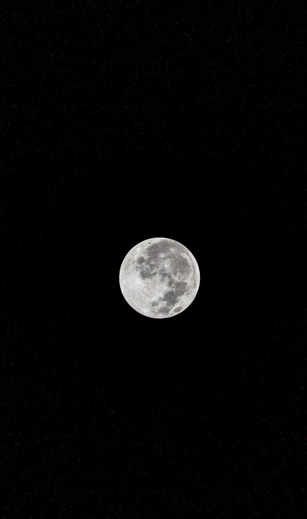 a full moon is seen in the night sky