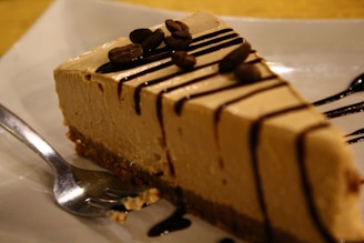a piece of cheesecake with chocolate sauce on a plate