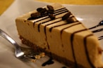 a piece of cheesecake with chocolate sauce on a plate