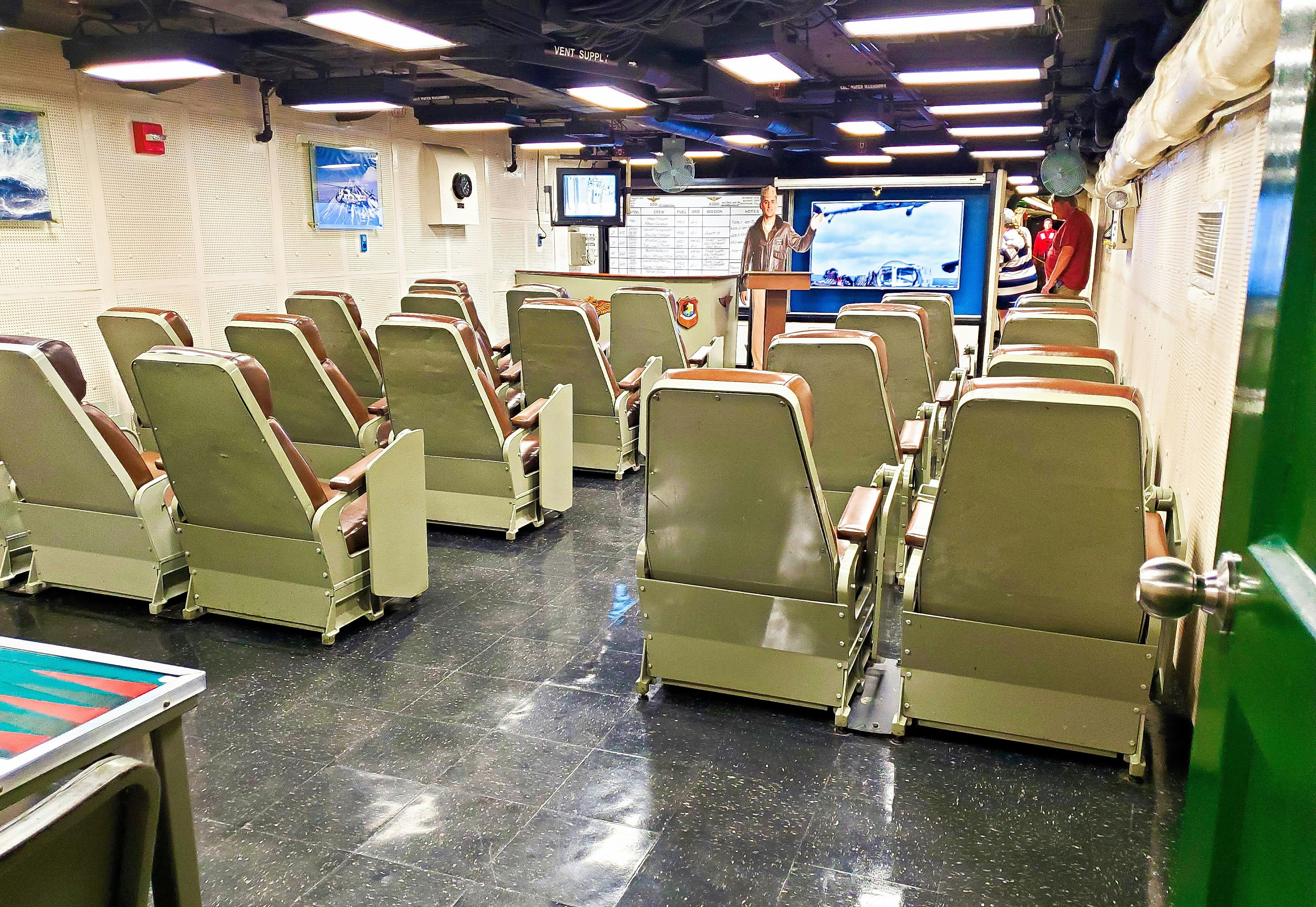a room filled with lots of green chairs