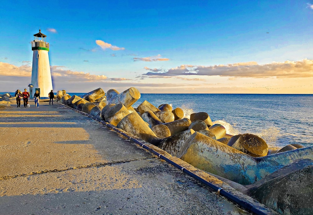 a light house sitting on top of a pier next to the ocean