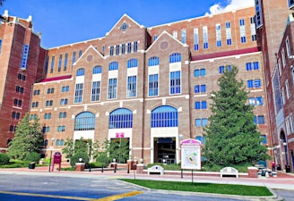 a large brick building with many windows and a sign in front of it