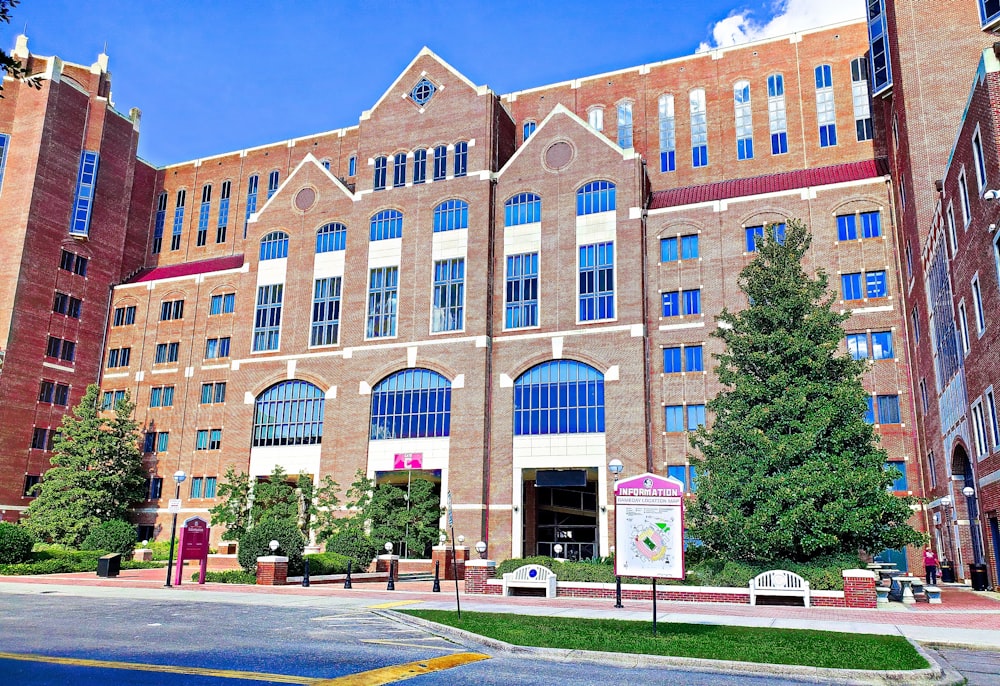 a large brick building with many windows and a sign in front of it